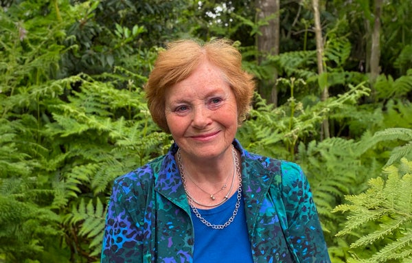 Een glimlachende vrouw voor bomen