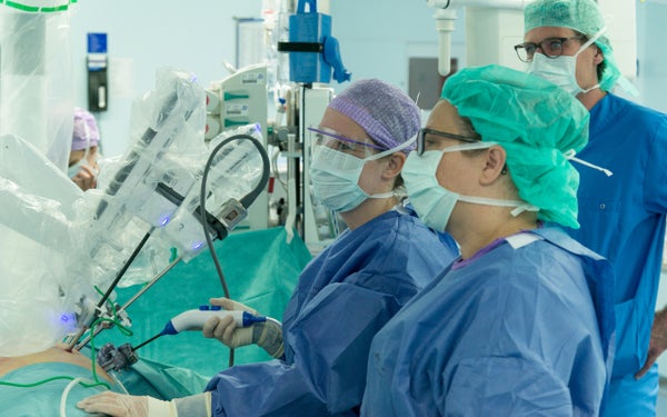 Twee chirurgen besturen een operatierobot.