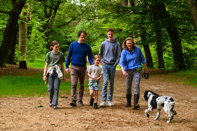 Een gezin wandelt met de hond in een bos