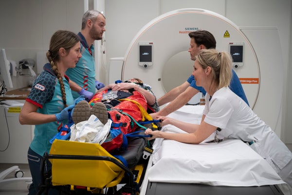 Zorgverleners staan bij een patiënt die op een brancard ligt