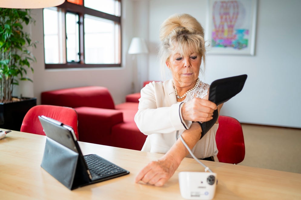 Een vrouw meet haar eigen bloeddruk