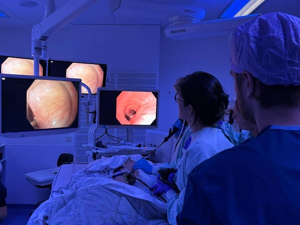 Roos Pouw en Joris van Dongen bekijken via een camera en scherm de slokdarm van een patiënt in de operatiekamer.