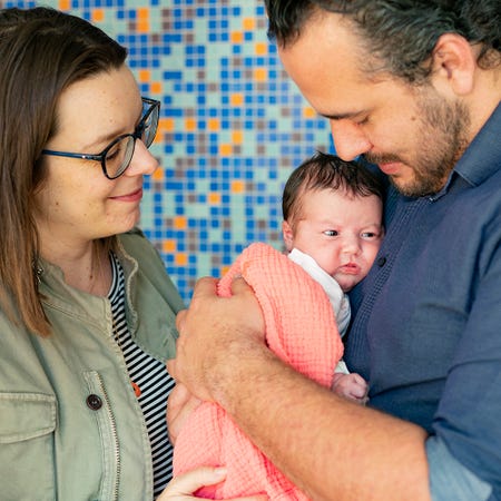Een man en vrouw die een baby vasthouden