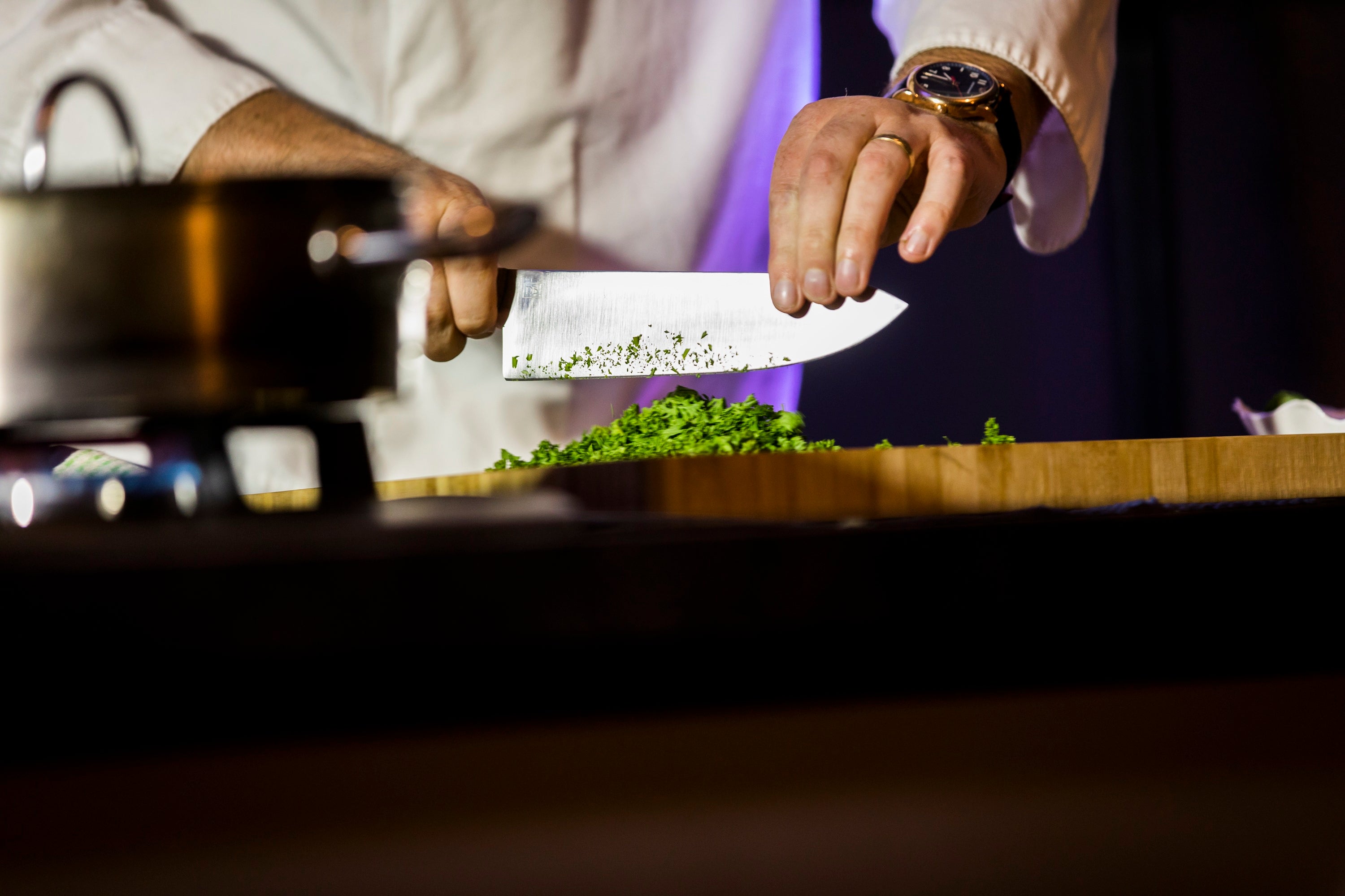 Kitchen staff setting up a breakfast buffet service, with a chef working at an open kitchen pass