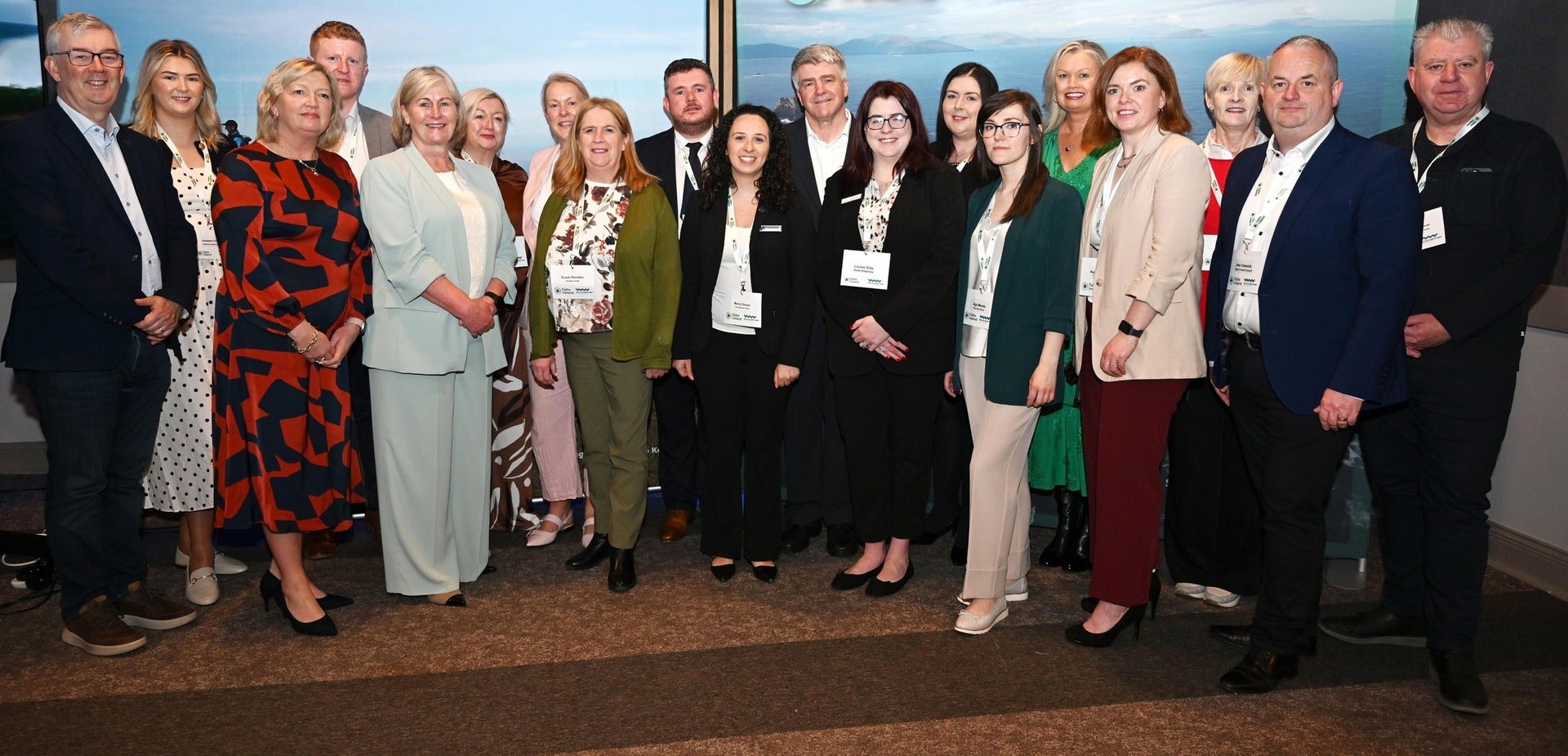 Large group of tourism industry professionals posing for a photo at a conference with a Wild Atlantic Way branded backdrop at IMEX America