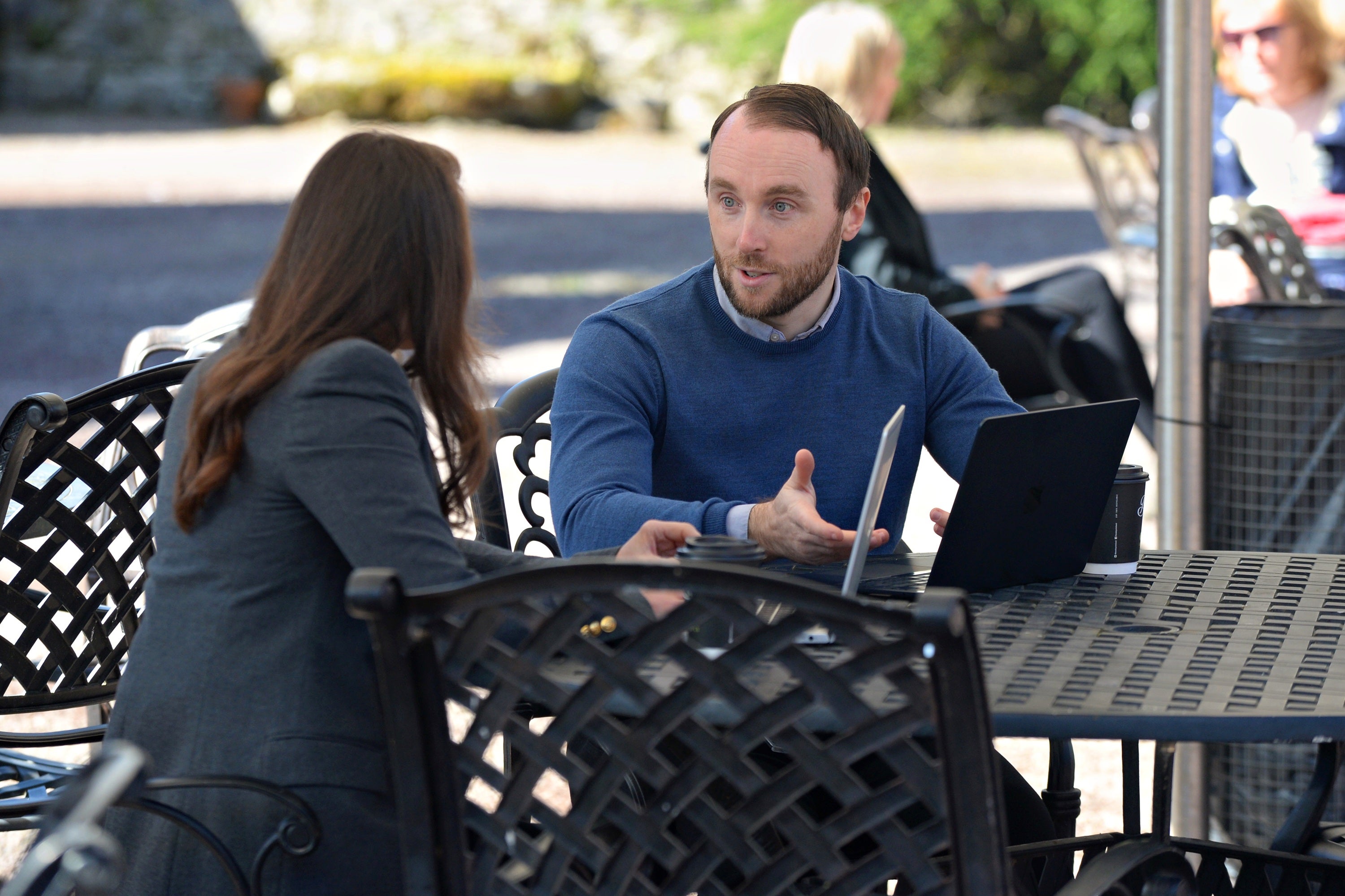 A man and woman sitting at a table with a laptop