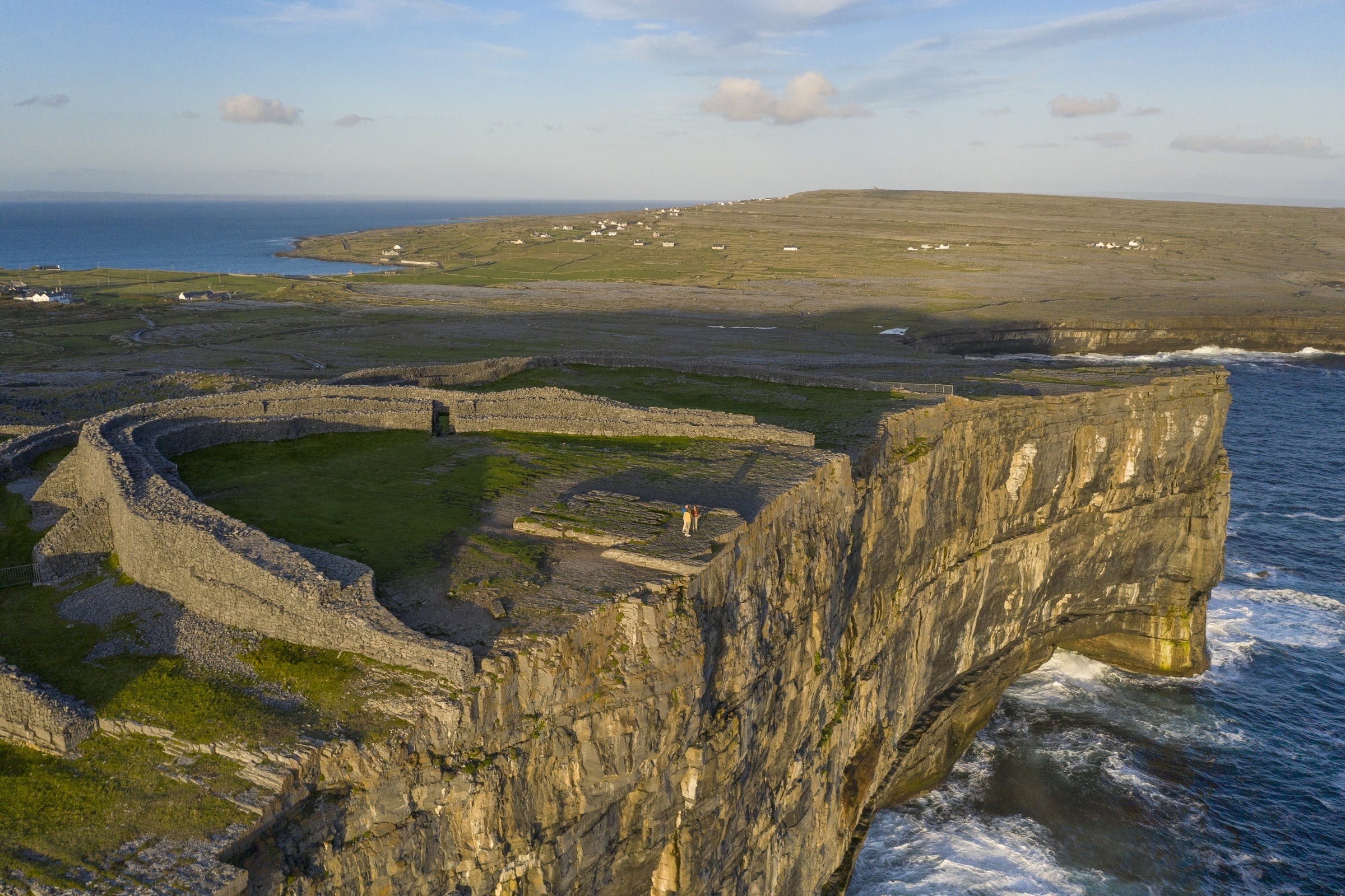 An arial view of sheer cliff faces dropping down to the sea.