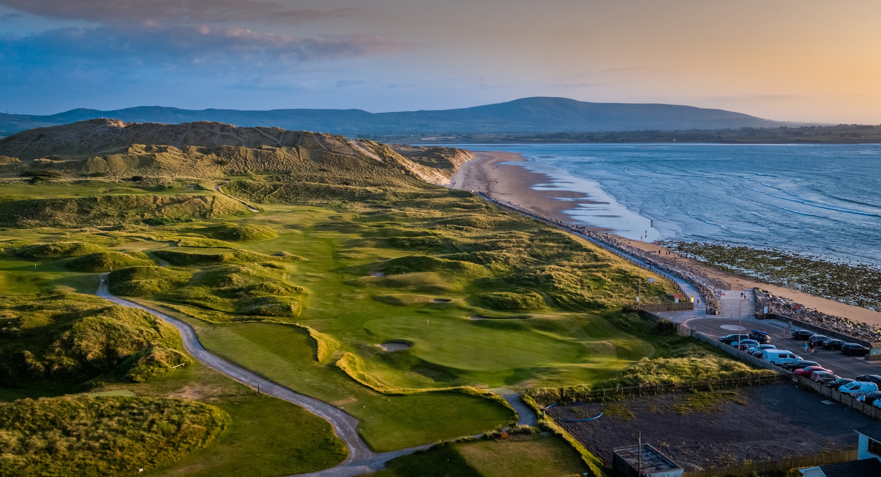 A golf course with a beach and water