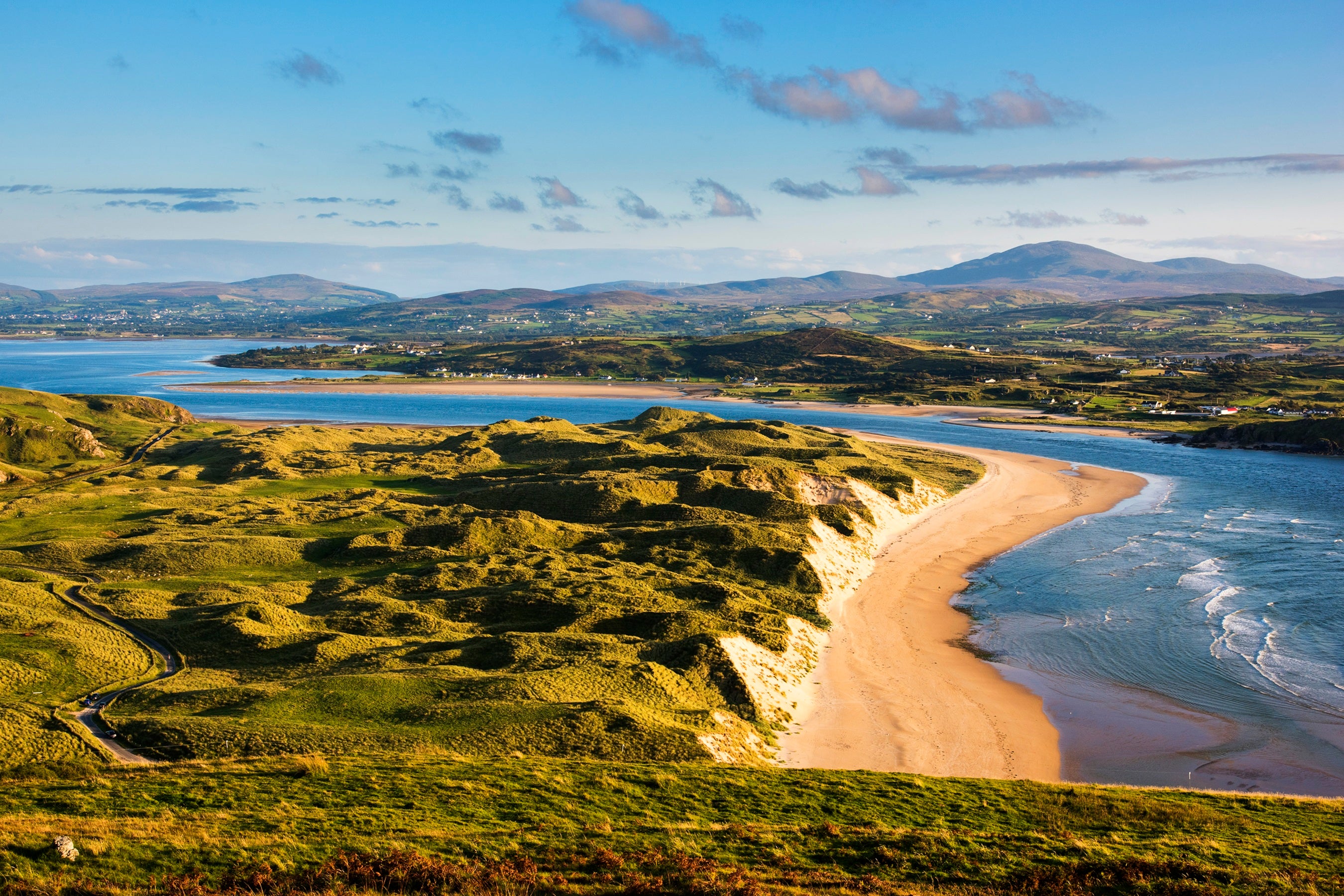 A beach with a body of water and hills