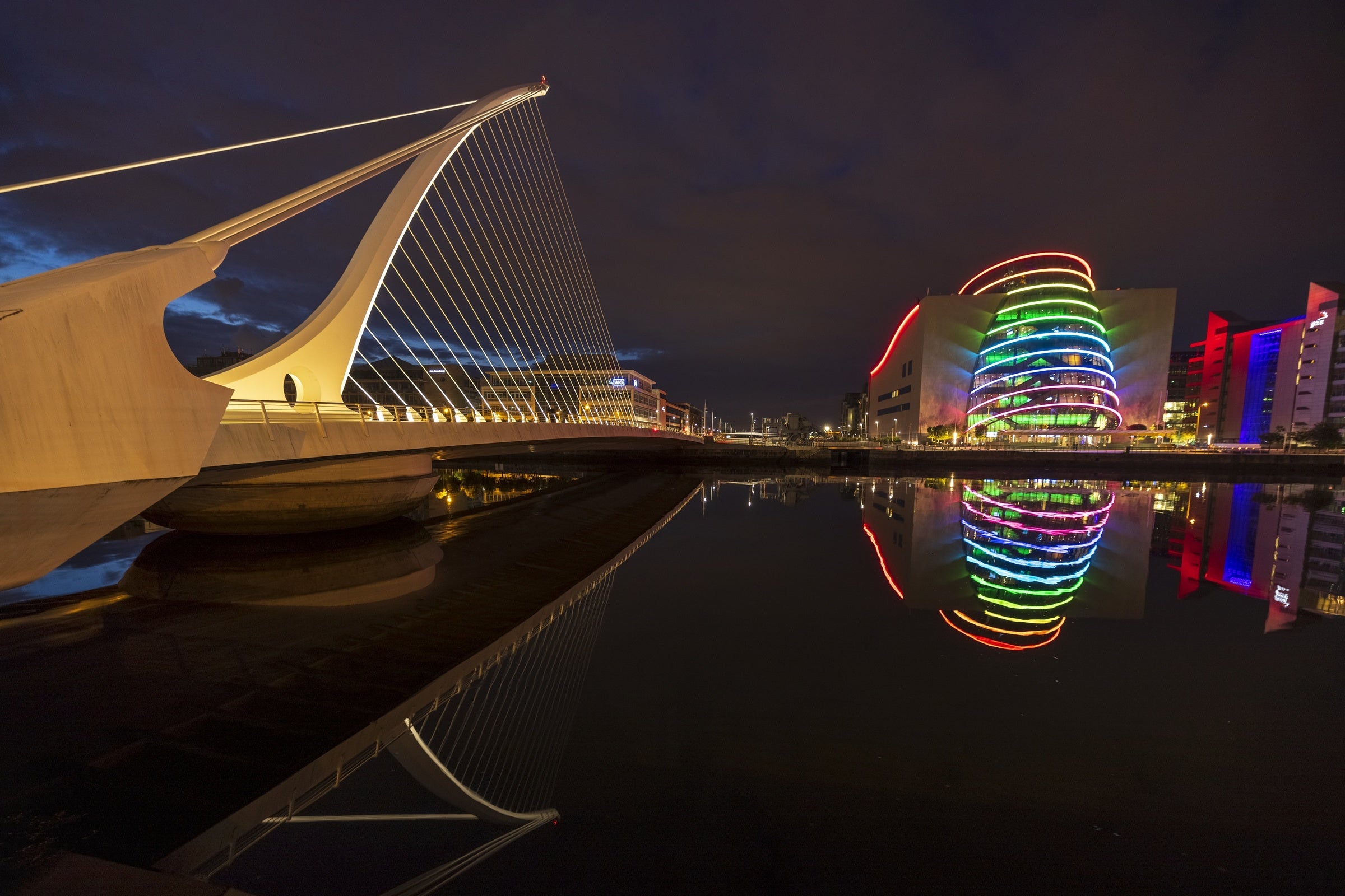 A photo taken at night time showing a bridge and the National Convention Centre in Dublin