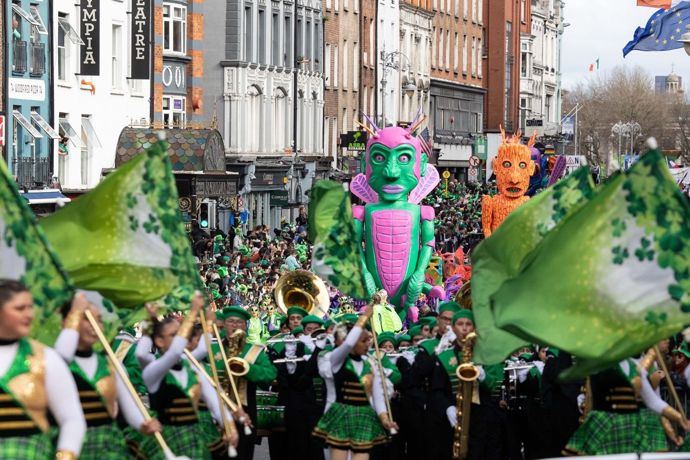 Floats and flag bearers march in the Saint Patricks day parade.