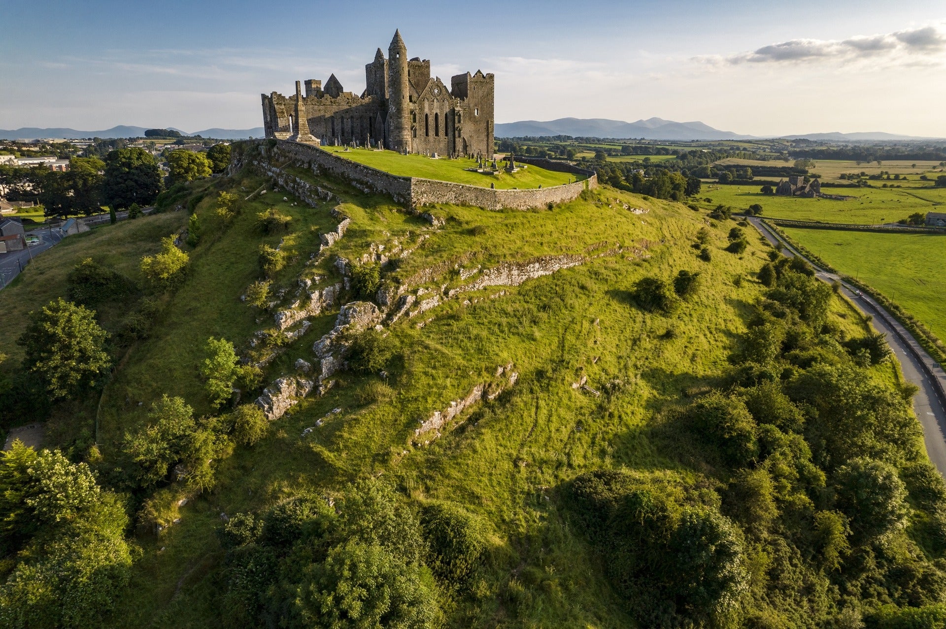 Aerial view of the Rock of Cashel, a medieval castle and cathedral on a limestone hill surrounded by green countryside in County Tipperary