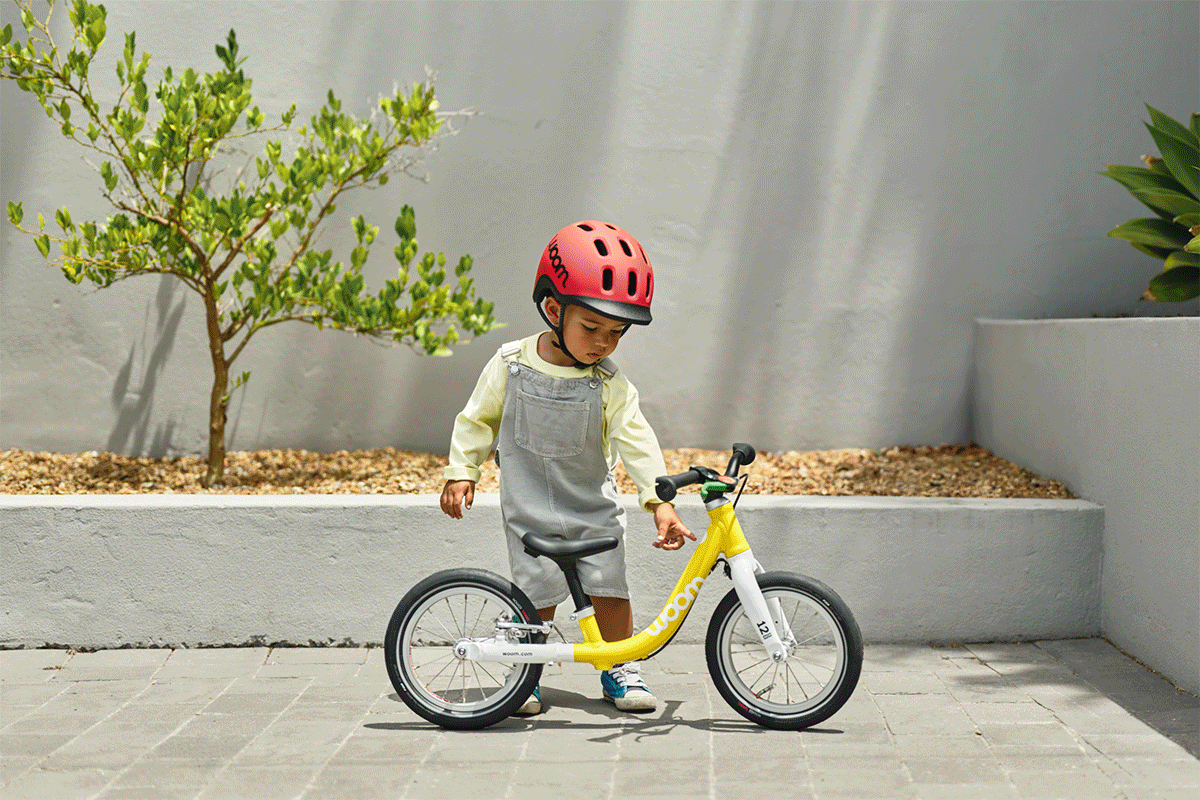 Animation die abwechselnd Kinder verschiedenen Alters mit woom READY Kinderhelmen und woom GO bikes in verschiedenen Größen und Farben von Größe 1 bis Größe 4 zeigt.