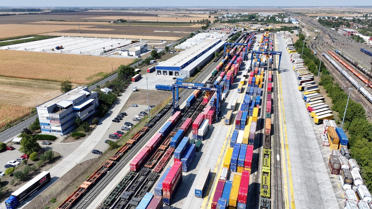 Aerial view of a busy freight train station with colorful containers.