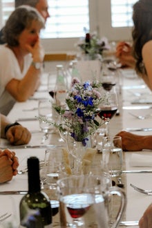 Galadinner: im Vordergrund Tischdekoration und im Hintergrund mehrere Personen