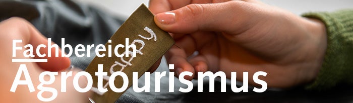 Zwei Hände halten ein Schildchen mit Happy