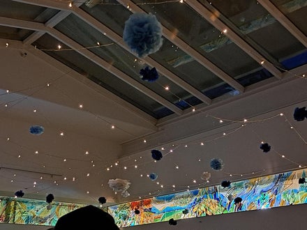 dekorierte Halle mit Lichterketten und Papierblüten 