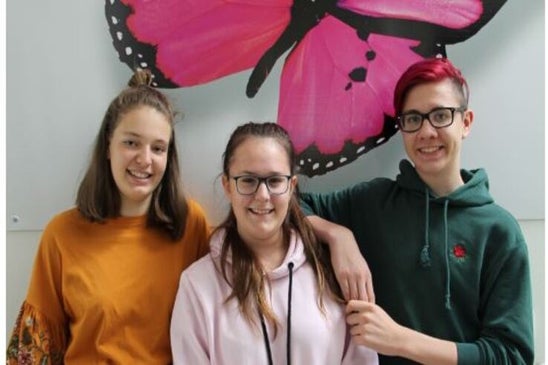 Titelbild der Schulzeitung. Es sind zwei Schülerinnen und ein Schüler abgebildet.