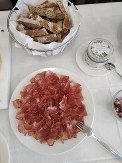 Im Vordergrund steht ein Speckteller und im Hintergrund geschnittenes Brot