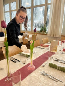 Schülerin beim Aufdecken der Tische