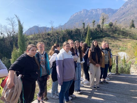 Schülerinnen besichtigen den Hof des Wandels in St. Pauls. Im Hintergrund sind Sträucher zu sehen.