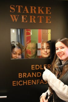 Schülerinnen stehen bei einer Schautafel zu "Starke Werte"