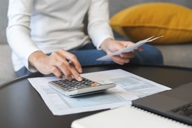 Osoba používajúca kalkulačku a papier