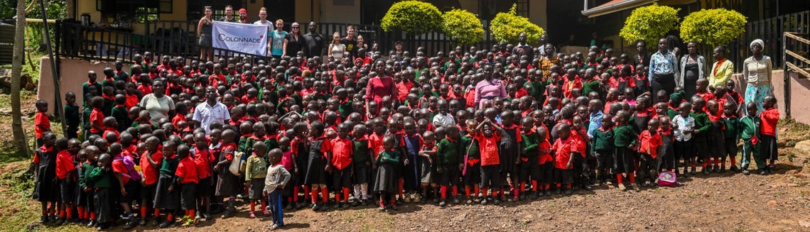 Skupina dětí v Africe pózuje s vlajkou Colonnade