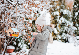 Dieťa v kabáte a čiapke stojace v snehu