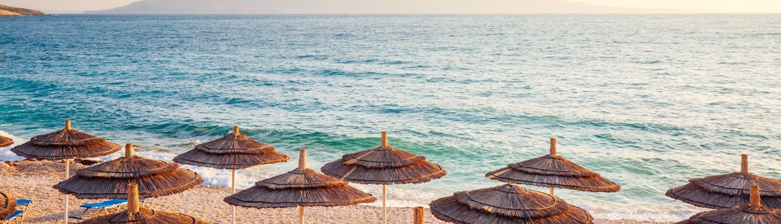 Skupina slaměných slunečníků na pláži