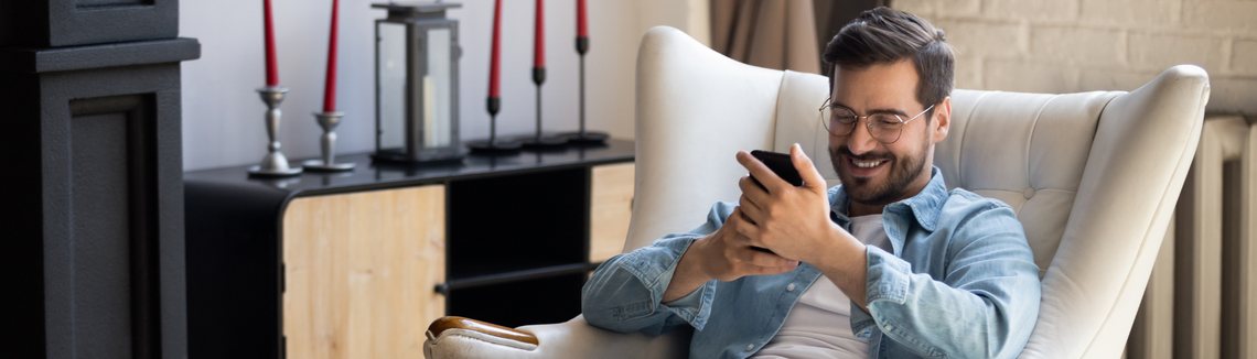 Egy székben ülő személy, kezében egy telefonnal