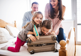 Група хора, които се усмихват и си играят с куфар