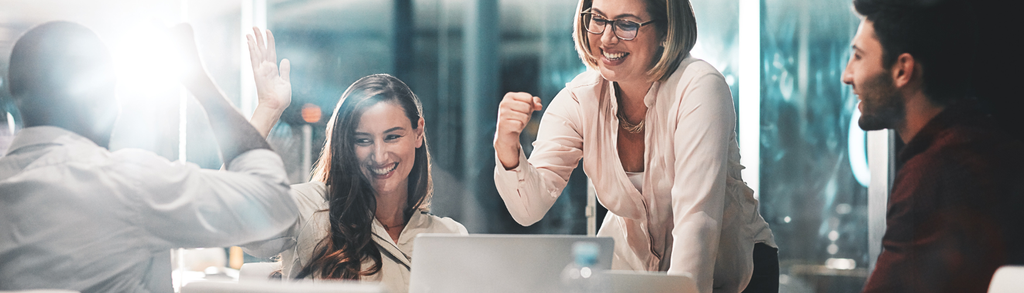 Grupa osób na spotkaniu biznesowym, patrzą na laptopa