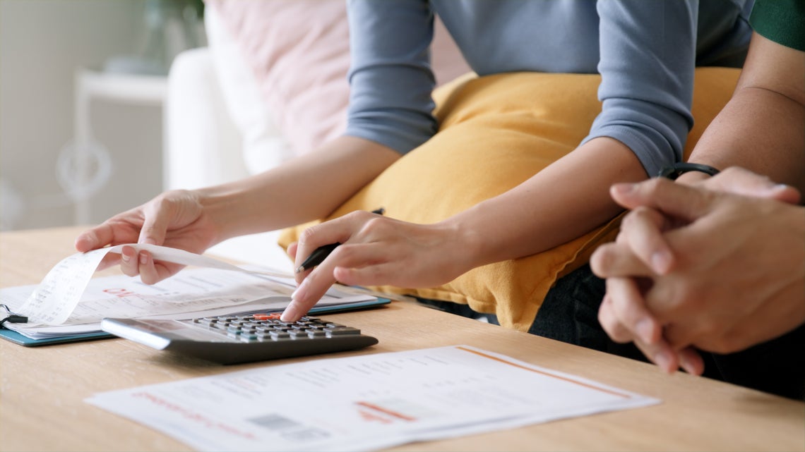 Žena a muž používajú kalkulačku