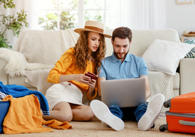 Mężczyzna i kobieta siedzący na podłodze i patrzący na laptopa