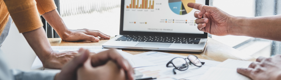 Un prim-plan al mâinilor care indică un grafic de plăcintă pe un laptop