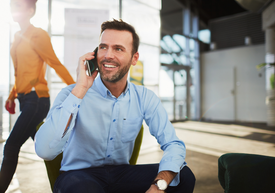 Telefonující muž sedící na židli 