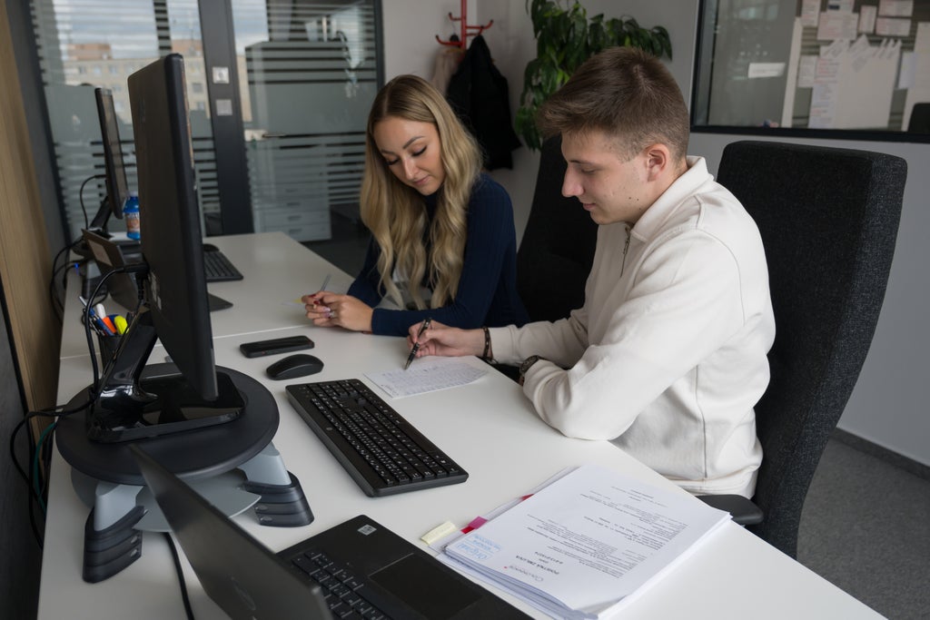 Muž a žena sedia za stolom s počítačom