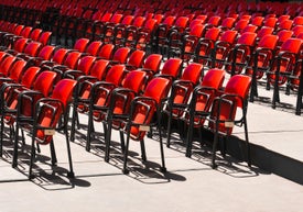 Řady červených židlí na pódiu