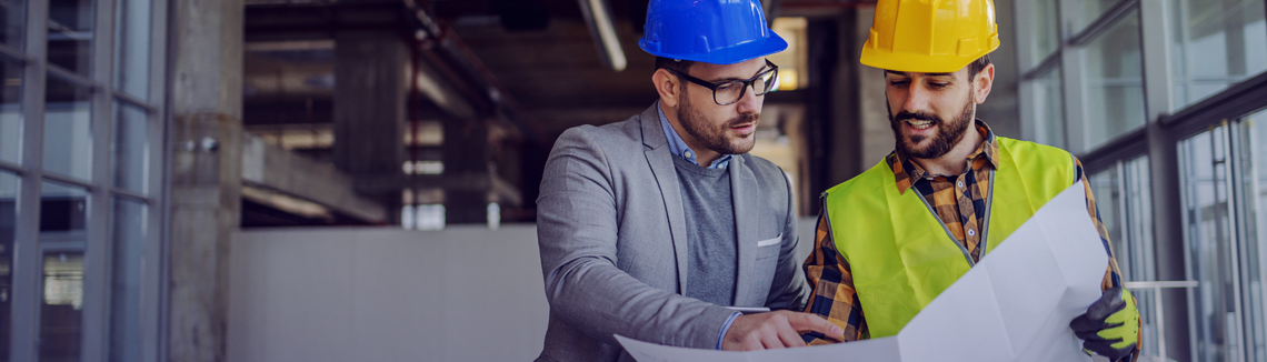 Egy férfi keménykalapot visel és egy papírlapot néz.