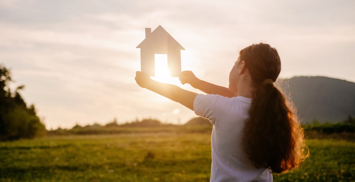 Dievča drží papierový domček