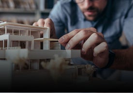 Mężczyzna pracujący nad modelem domu