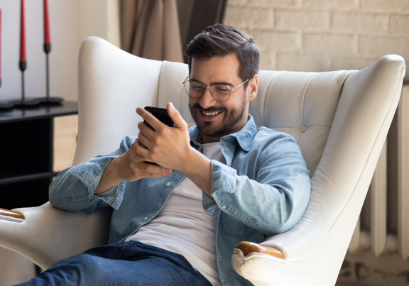 Egy székben ülő személy, kezében egy telefonnal