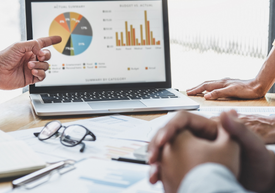 Un prim-plan al mâinilor care indică un grafic de plăcintă pe un laptop