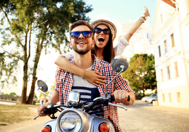 Un bărbat și o femeie care călăresc un scuter