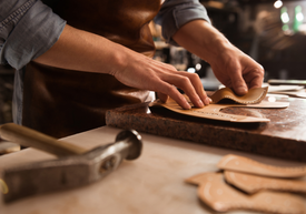 Egy bőrműves munkát végző személy