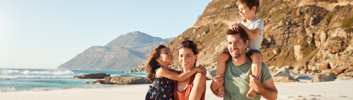 Край морски бряг млад баща носи на конче сина си, а майката на ръце дъщерята.