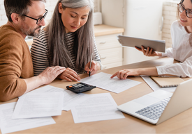 Muž a žena si prezerajú papiere na stole