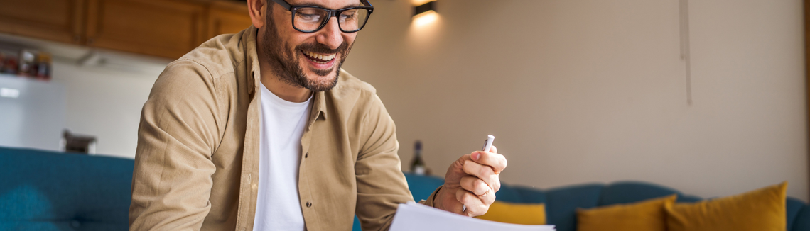 Muž, ktorý sa usmieva a drží pero