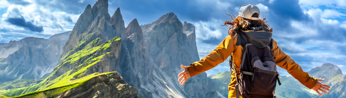 Egy személy kinyújtott karral a hegységben